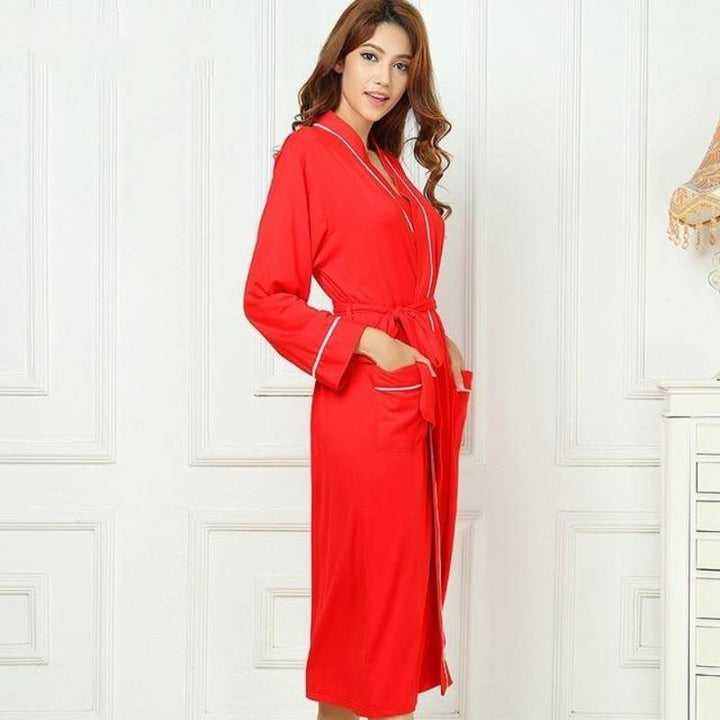 Woman wearing a red Bamboo Kimono luxury Spa Robe with white piping. 